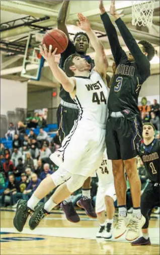  ?? JIM TRYON/FOR DIGITAL FIRST MEDIA ?? CB West’s Jake Reichwein goes up for a bucket in between Roman Catholic defenders Saturday.