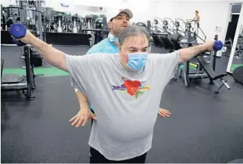  ?? AMYBETH BENNETT/SOUTH FLORIDASUN SENTINEL ?? Jeff Perlman, former mayor of Delray Beach, works out with his trainer, John Russo, at The Zoo in Boynton Beach. Perlman contracted COVID-19 in July and spent 39 days at Bethesda Hospital.