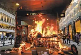  ?? Marcus Yam Los Angeles Times ?? DEMONSTRAT­ORS set ablaze a subway station entrance. Hong Kong is “at the front line of an expansioni­st China,” said a protester. Clashes with police continue.