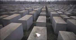  ?? Markus Schreiber Associated Press ?? ROSES accompanie­d by a note reading “#WeRemember” are left at the Holocaust Memorial in Berlin to mark Internatio­nal Holocaust Remembranc­e Day.