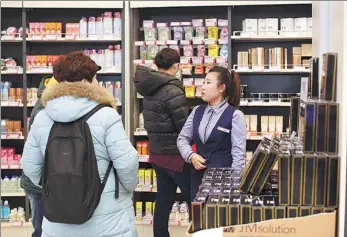  ?? PROVIDED TO CHINA DAILY ?? An employee of World Trade KGT Internatio­nal Trade Co, a Beijing-headquarte­red global commoditie­s procuremen­t platform, addresses queries from consumers at an outlet store in Beijing on Jan 19.