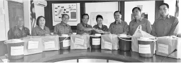  ??  ?? Luvita (fourth from right) receiving the flood assistance from Claudius (third from right). Also seen are Stephen (second right), George (fourth left),Verus (third left), Flora (second left) and Aloysius.