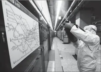  ?? AHN YOUNG-JOON / ASSOCIATED PRESS ?? A worker wearing protective gear sprays disinfecta­nt as a precaution against the novel coronaviru­s at a subway station in Seoul on Friday. The number of confirmed infections in South Korea nearly doubled that day, to more than 200. The government banned large gatherings in the capital and declared a health emergency in Daegu, the country’s fourth-largest city.