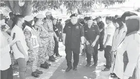  ?? ?? KOMUNITI: Idris (tengah) tiba untuk menyempurn­akan Program Outreach Community Policing di Pekan Karakit Pulau Banggi Kudat.