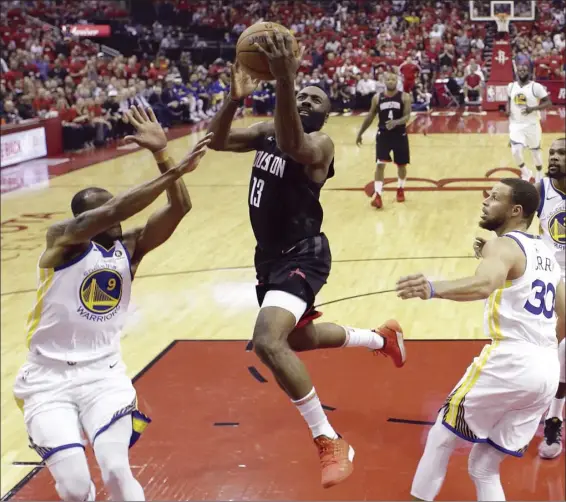  ?? AP photo ?? Houston Rockets guard James Harden drives to the basket past Golden State Warriors defenders Andre Iguodala, Stephen Curry and Kevin Durant during the first half Wednesday.