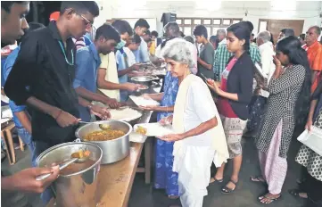  ?? — Reuters photo ?? A flood-affected woman receives food inside a college auditorium, which has been converted into a temporary relief camp, in Kochi in the southern state of Kerala.