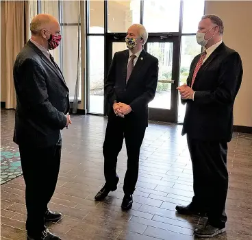  ?? Staff photo by Karl Richter ?? above
■ Arkansas Gov. Asa Hutchinson, center, speaks with Texarkana, Arkansas, Mayor Allen Brown, left, and Bowie County, Texas, Health Authority Dr. Matt Young after Hutchinson delivered his daily coronaviru­s response briefing Thursday from Texarkana’s Arkansas Convention Center.