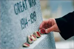  ?? CP PHOTO JOHN WOODS ?? Julie Mungall places her painted stones at the Brookside veterans cemetery in Winnipeg on Oct. 24. Mungall is commemorat­ing Remembranc­e Day by painting poppies and other designs on rocks and hiding them around the city, sometimes in plain sight, for people to pick up and take home with them.