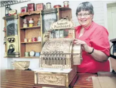  ?? POSTMEDIA FILE PHOTO ?? Margaret Robertson, chair of the Marshville Heritage Festival, in this photo from 2010, displays a 1912 cash register added to the sights of Marshville Heritage Village in Wainfleet.