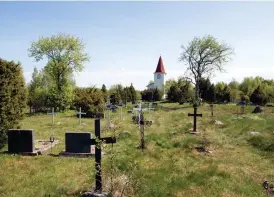  ??  ?? Den nuvarande kyrkan byggdes 1848. Svenska släktnamn är inristade i en stor del av korsen och gravstenar­na.