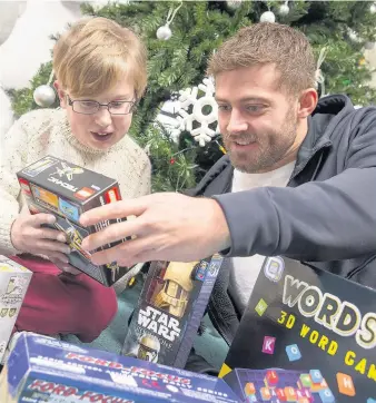  ??  ?? &gt; Leigh Halfpenny with gifts for children at Ty Hafan