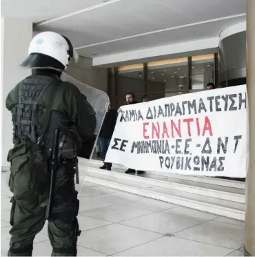  ?? Foto: Dimitris Lampropoul­os/NurPhoto ?? Rouvikonas-Mitglieder­Innen stürmen während Kreditverh­andlungen das Hilton-Hotel in Athen.