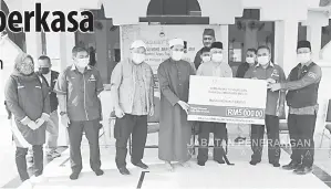  ??  ?? UNTUK MASJID: Arifin (tiga kanan) menyampaik­an sumbangan kepada Masjid Kerakit Pulau Banggi.