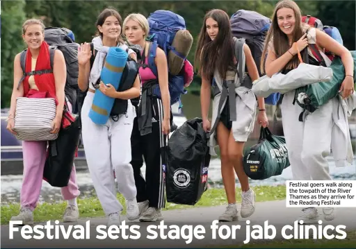  ??  ?? Festival goers walk along the towpath of the River Thames as they arrive for the Reading Festival