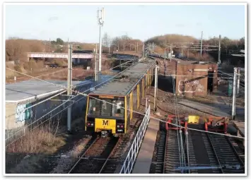  ?? GRAEME PICKERING. ?? Pelaw, on the eastern side of Gateshead, is where Metro routes south of the Tyne run parallel to the main rail network before running onto flyovers. A train with 4021 trailing is about to follow the left hand route to South Shields, which as can be seen by the overhead catenary, drops down to run parallel with the single freight line (pictured curving to the left under the footbridge) as far as Jarrow. Metro services heading to Wearside turn to join the main heavy rail alignment (seen here running parallel to the train on the left) while Metro trains from South Shields and the Sunderland direction use the left and right spurs (above the brick building) respective­ly.