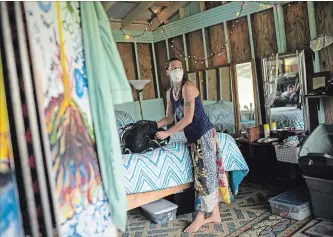  ?? TAMIR KALIFA NEW YORK TIMES ?? Stefani Hinkle prepares to evacuate her home in Pahoa, Hawaii, after an eruption from the Kilauea volcano, Thursday. The volcano erupted from its summit on Thursday morning, spewing an ash plume.