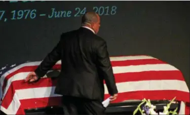  ?? KRISTI GARABRANDT — THE NEWS-HERALD ?? Mike Mazany, brother of fallen Mentor police officer, Ptl. Mat Mazany takes a moment to touch the coffin holding his brother’s remain after delivering the eulogy at the July 2 memorial service.
