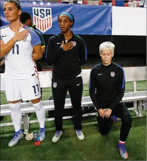  ?? JOHN BAZEMORE/AP 2016 ?? U.S. women’s soccer player Megan Rapinoe kneels next to teammates Ali Krieger (11) and Crystal Dunn as the national anthem is played before an exhibition match.