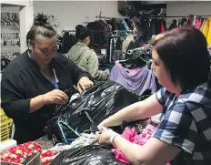  ?? ERIN PETROW ?? Justine Nabess, left, Lu Gu and Chantelle Tutka sort donations for the Saskatoon Food Bank Clothing Depot on Thursday. The Clothing Depot helps those fighting poverty by providing clothing, toiletries and housewares that can be purchased for as little as $2 per bag.