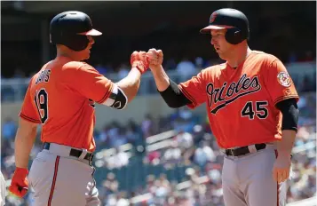  ?? Associated Press ?? ■ Baltimore Orioles' Chris Davis, left, is greeted by Mark Trumbo following a two-run home run by Davis off Minnesota Twins pitcher Kyle Gibson in the first inning of a baseball game Saturday in Minneapoli­s.