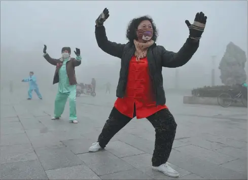  ?? LU QIJIAN / FOR CHINA DAILY ?? Morning exercisers brave heavy smog in Fuyang, Anhui province, on Sunday. Nearly half of the country is choked in some of the worst air this year.