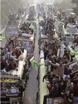  ?? — AP ?? Seeking reforms: Busloads of Qadri supporters heading towards Islamabad.