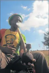  ??  ?? UP IN SMOKE: Rastafaria­n Papa Levi Zeida enjoys the holy herb