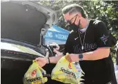  ?? JORDAN MCPHERSON jmcpherson@miamiheral­d.com ?? Miami Marlins shortstop Miguel Rojas hands out food at a drive-thru distributi­on at Marlins Park on Wednesday. He’s committed to carrying team momentum into 2021.