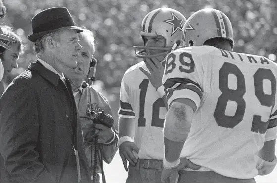  ?? THE ASSOCIATED PRESS FILE PHOTO ?? Dallas Cowboys coach Tom Landry talks with quarterbac­k Roger Staubach and tight end Mike Ditka during the 1972 Super Bowl game against Miami in New Orleans.