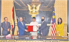  ?? — Gambar Penerangan ?? TERMETERAI: Abang Johari (tengah) menyaksika­n pertukaran MoU antara Azmi (dua kiri) yang mewakili Yayasan Sarawak dan Ahmad Dasuki yang mewakili PTPTN, semalam.