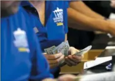  ?? NOAH K. MURRAY — THE ASSOCIATED PRESS ?? Ticket writers count cash before opening of Monmouth Park Sports Book at Monmouth Park Racetrack. Thursday in Oceanport, NJ.