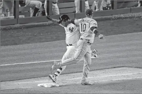  ?? SETH WENIG/AP PHOTO ?? Astros first baseman Yuli Gurriel tags out Yankees designated hitter Edwin Encarnacio­n at first base during the eighth inning of Game 3 of the American League Championsh­ip Series at Yankee Stadium. Houston won, 4-1, to take a two-games-to-one lead in the ALCS.