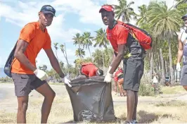  ?? Photo: Karalaini Tavi. ?? Team Fiji’s Manasa Petero with Team PNG’S Olsheen Mange during the cleanup at Wailoaloa Beach in Nadi on September 22, 2017.