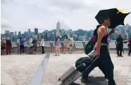  ?? Photo: Jelly Tse ?? Tourists take photos of the harbour in Tsim Sha Tsui. More than 2,000 influencer­s were invited to the city to promote tourism.