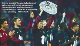  ?? – REUTERSPIX ?? Bayern Munich’s Thomas Muller (centre) celebrates with a replica trophy with teammates after winning the match against Borussia Dortmund at the Allianz Arena yesterday.