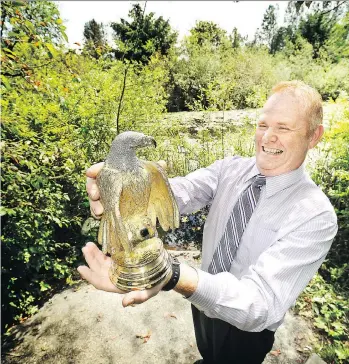  ?? BILL KEAY ?? Ronald Shore holds a diamond-encrusted golden eagle in 2010. In 2016, Shore reported that two masked thieves attacked him outside a Ladner church and stole the statue.