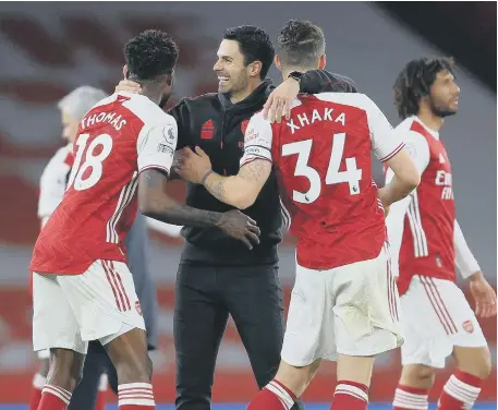  ??  ?? Arsenal manager Mikel Arteta celebrates with Thomas Partey and Granit Xhaka after the derby victory.