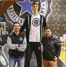  ?? ANDREW MEDICHINI / AP ?? Romanian teenager Robert Bobroczkyi, who stands 7-foot-7, towers over A.S. Stella Azzurra GM Giacomo Rossi (left) and club President Fabio de Mita.