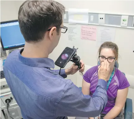  ?? WAYNE CUDDINGTON ?? Dr. JP Vaccani, an ear, nose and throat specialist at CHEO, demonstrat­es the Clearscope on Molly Brown, RPN.