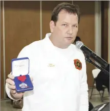  ?? Photos by Katie West ?? Forrest City Fire Chief Shane Dallas holds up a Medal of Valor, the highest award given by the FCFD, that several fire department employees received due to their actions during the shooting that took place Feb. 10 at Walmart. Dallas told the city that the bravery of the crew that responded to the shooting likely help save FCPD Detective Eugene Watlington’s life.