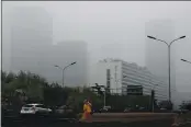 ?? ANDY WONG — THE ASSOCIATED PRESS ?? A cleaner wearing a mask against pollution sweeps a street in Beijing in November 2018. The world cut its daily carbon dioxide emissions by 17% at the peak of the pandemic shutdown last month, a new study found.