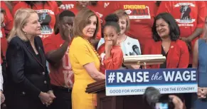  ??  ?? Speaker of the House Nancy Pelosi, D-calif., hoists Kassidy Durham, 7, who lives in Durham, N.C., where her mother works for Mcdonald’s. House Democrats approved legislatio­n to raise the federal minimum wage for the first time in a decade.