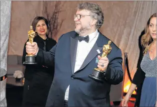  ?? AP PHOTO ?? Guillermo del Toro poses with his awards for best director and best picture for “The Shape of Water” at the Governors Ball after the Oscars on Sunday, March 4, 2018, at the Dolby Theatre in Los Angeles.