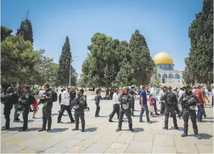  ?? (Jamal Awad/Flash90) ?? SECURITY FORCES guard a group of Jews during a visit to the Temple Mount on Tisha Be’av yesterday.