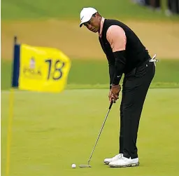  ?? Associated Press ?? ● Tiger Woods putts on the 18th hole Saturday during the third round of the PGA Championsh­ip golf tournament at Southern Hills Country Club in Tulsa, Okla.