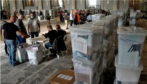  ?? ?? Heads of polling stations and clerks receive ballot boxes for Sunday's parliament­arian elections in Beirut, Lebanon, May 14, 2022.