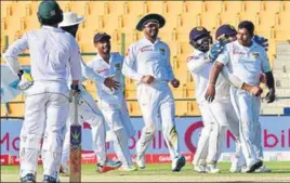  ?? AFP ?? Sri Lanka’s bowling hero Rangana Herath mobbed by his jubilant teammates as Pakistan slide to defeat in the first test at Abu Dhabi on Monday.