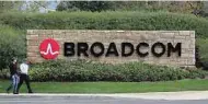  ??  ?? Men walk past Broadcom’s Logo in its campus in California. — AFP