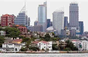  ?? — Bloomberg. ?? Luring investors: A view of the central business district and the water-front residentia­l properties in Point Piper, Sydney. As Golden Week began yesterday, real estate agents are taking Chinese visitors on tours to show off prestigiou­s Australian...