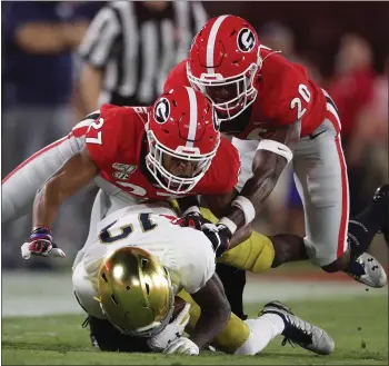  ?? JOHN BAZEMORE — THE ASSOCIATED PRESS ?? Notre Dame wide receiver Lawrence Keys III takes a big hit from Georgia defenders Eric Stokes, middle, and J.R. Reed.